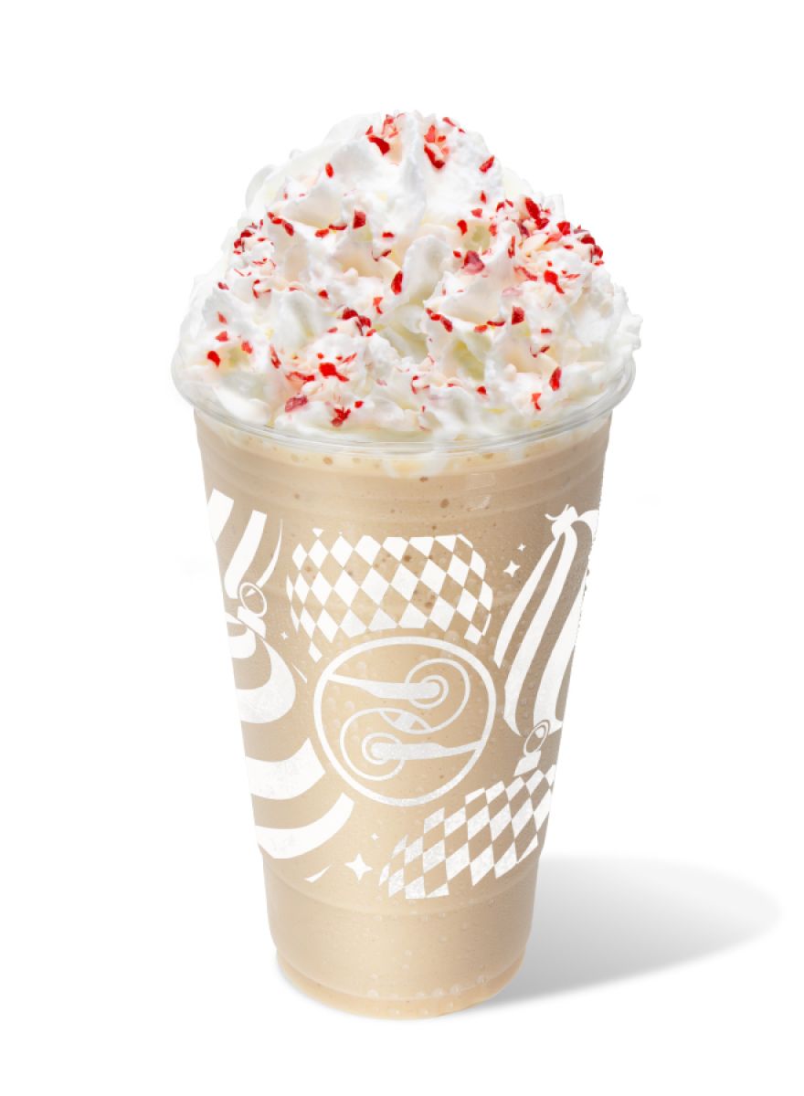 Blended Candy Cane Crunch Latte topped with whipped cream and crushed candy canes in a blue Ziggi’s holiday cup.